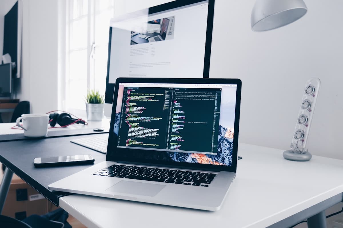 A focused developer's workspace with a laptop running code